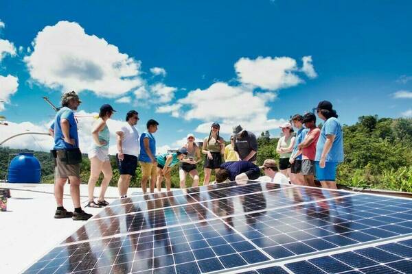 Students stand and look at solar panels